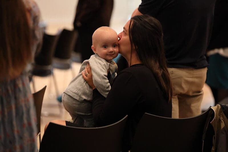 A mother kissing her baby on the cheek during the service