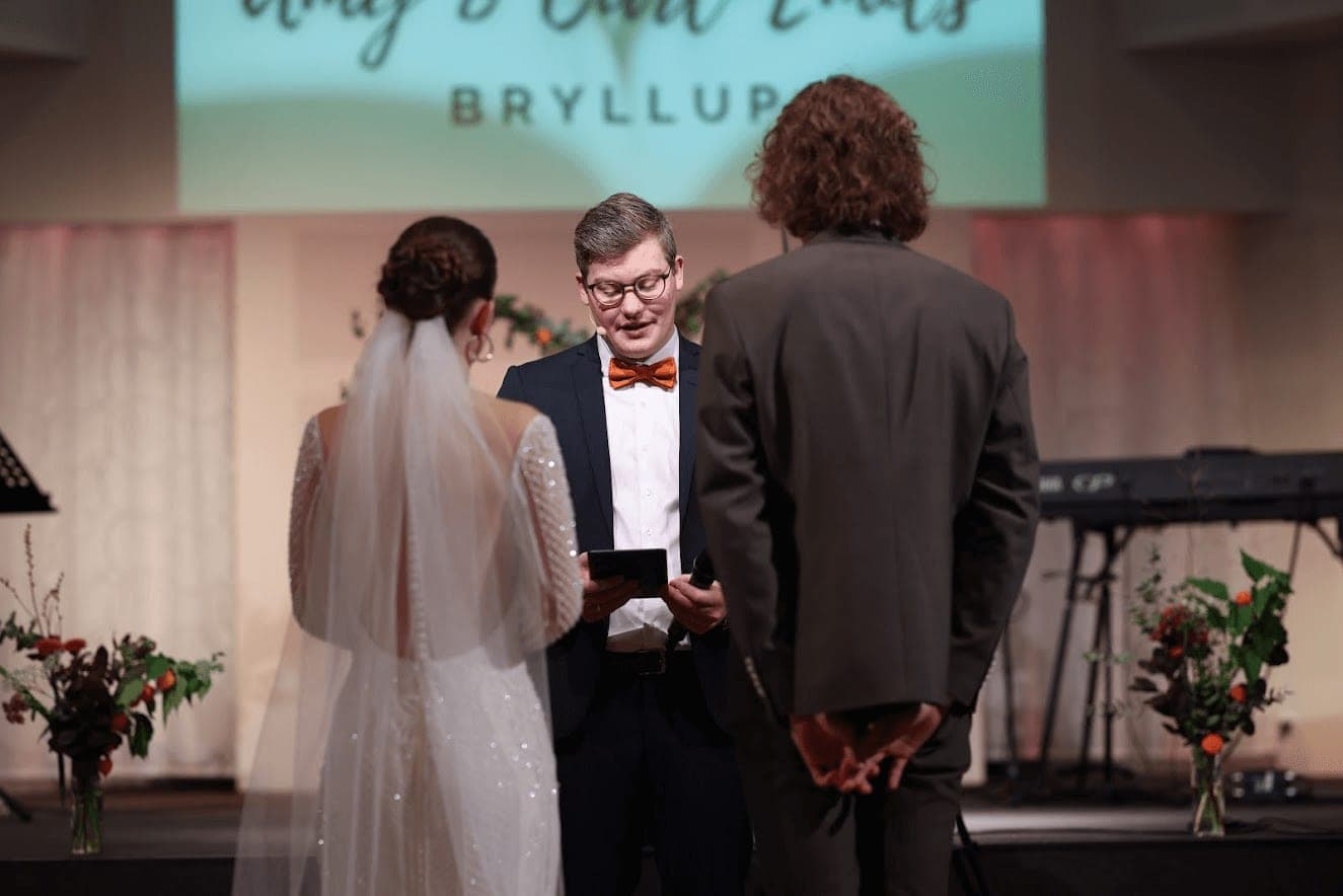 A bride and groom standing before the pastor during their wedding ceremony in the church